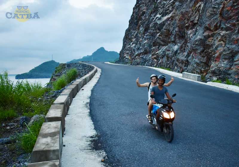 Traveler riding a motorbike along Cat Ba Island coastal road
